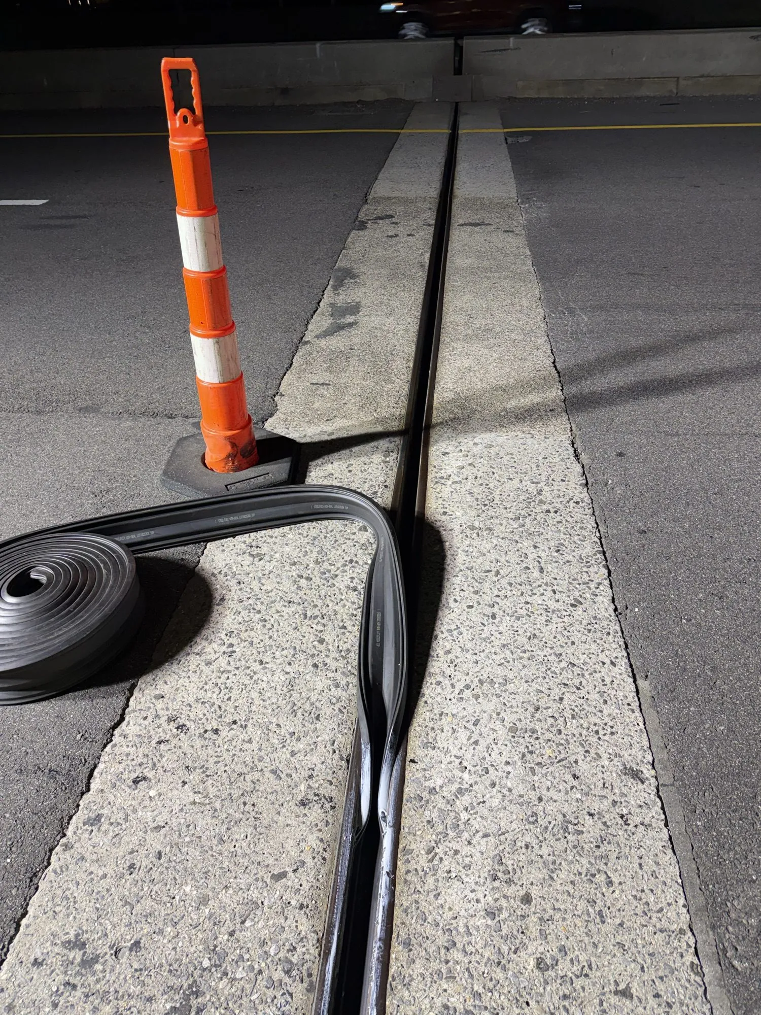 Asphaltic plug expansion joint and a roll of waterproofing membrane staged on a bridge deck