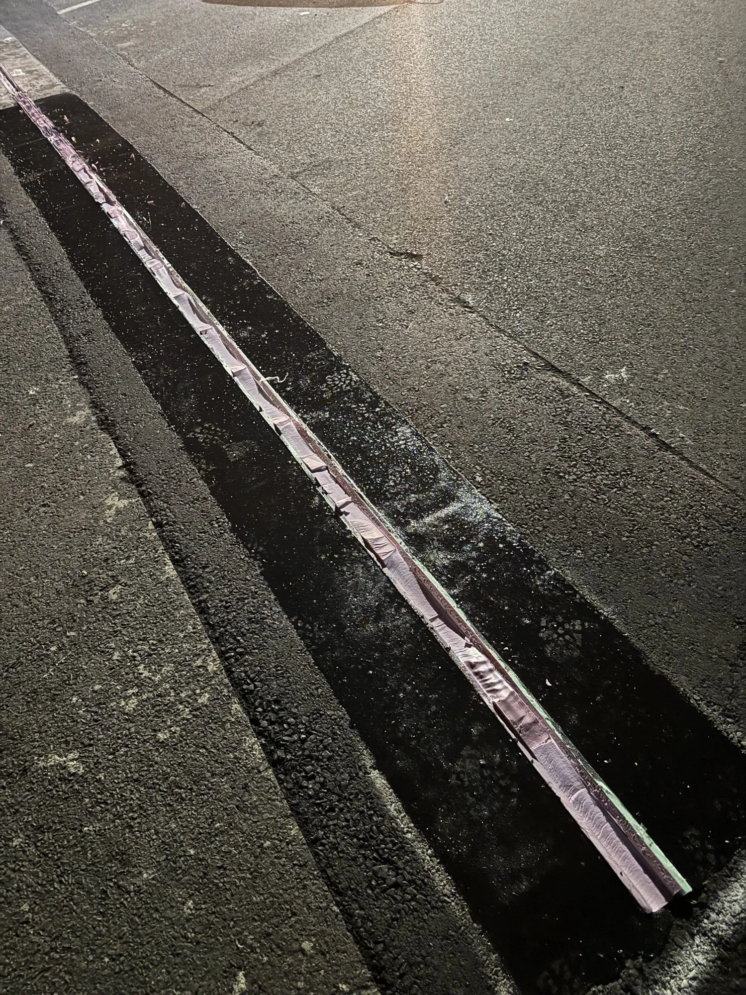 Close-up of a finished crack seal routed and filled along a state highway lane line
