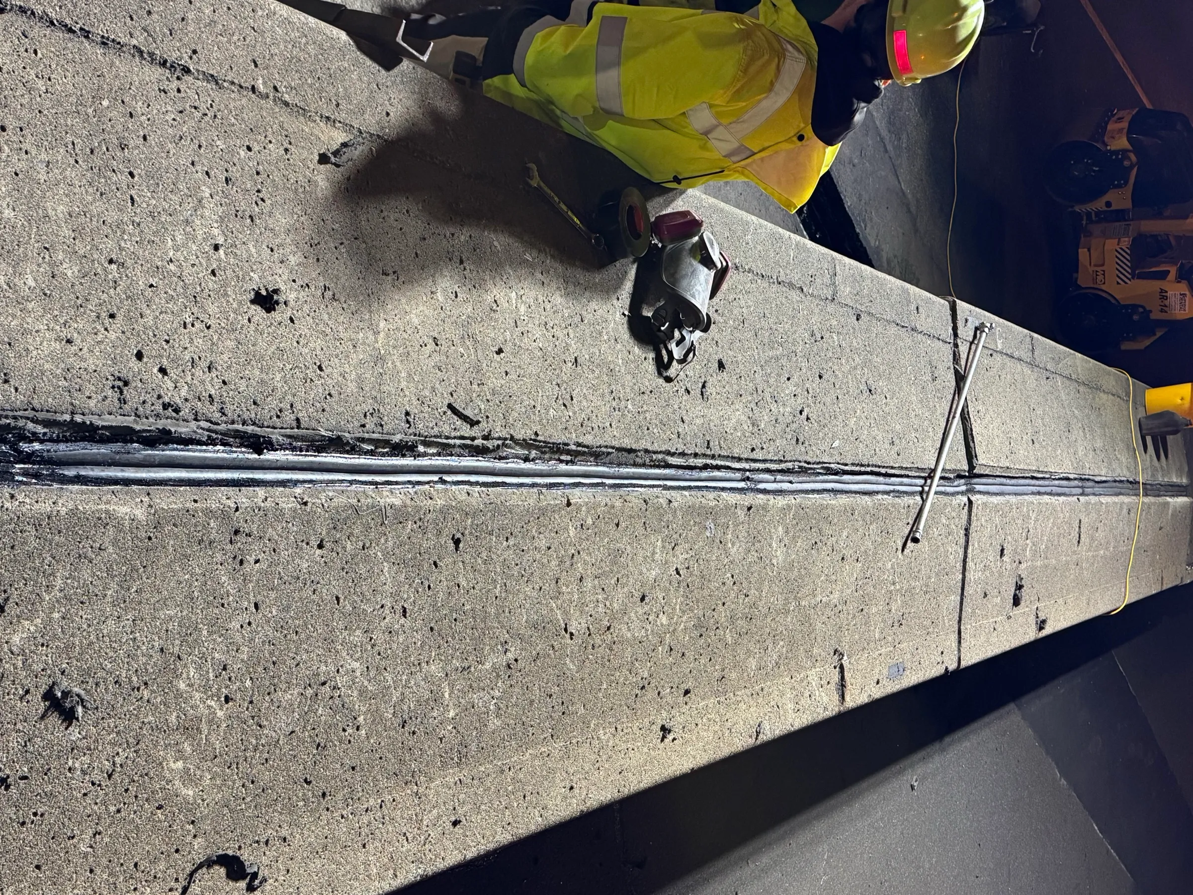 Cristiano & Son crewman sealing a bridge expansion joint on a concrete deck overnight