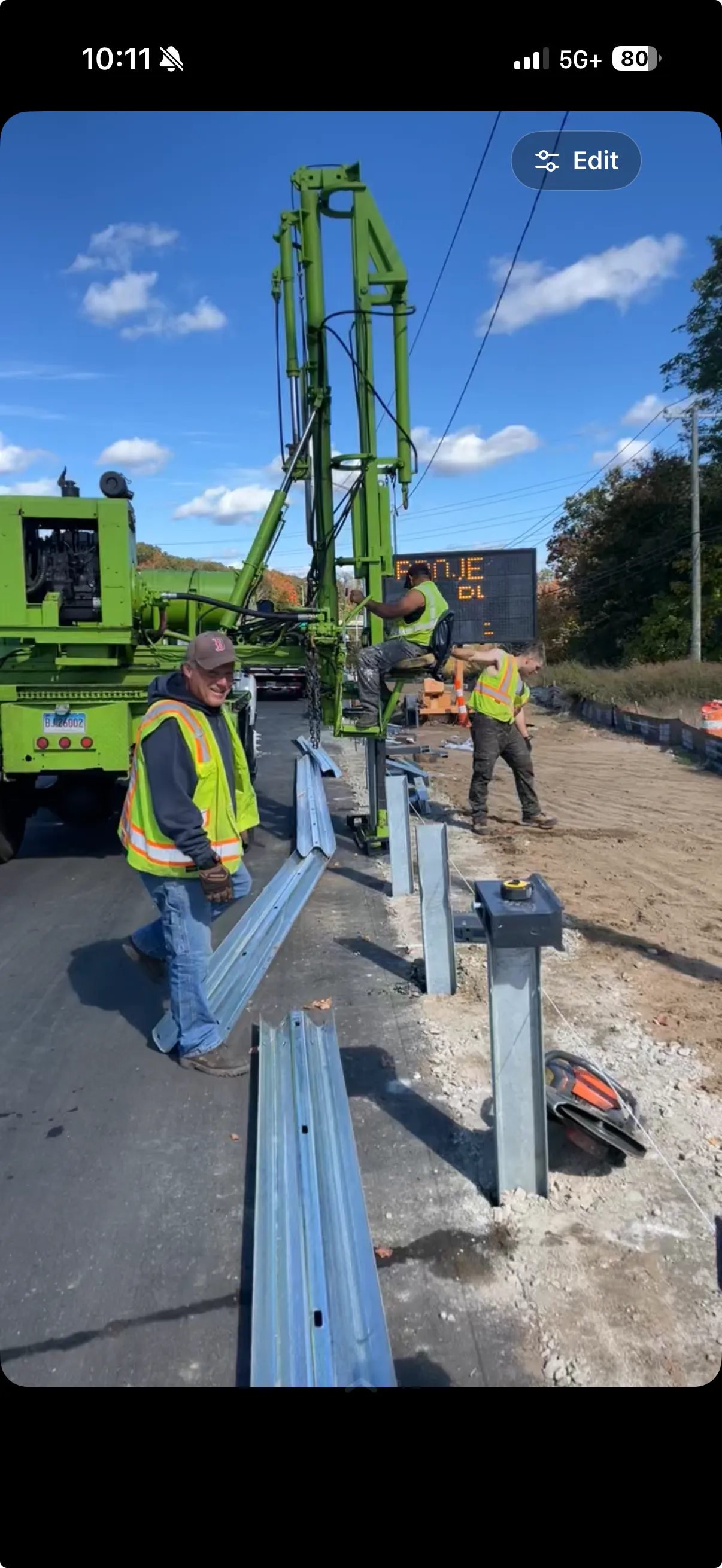 Active guardrail installation: tracked post-driving rig and crew installing new steel guardrail posts